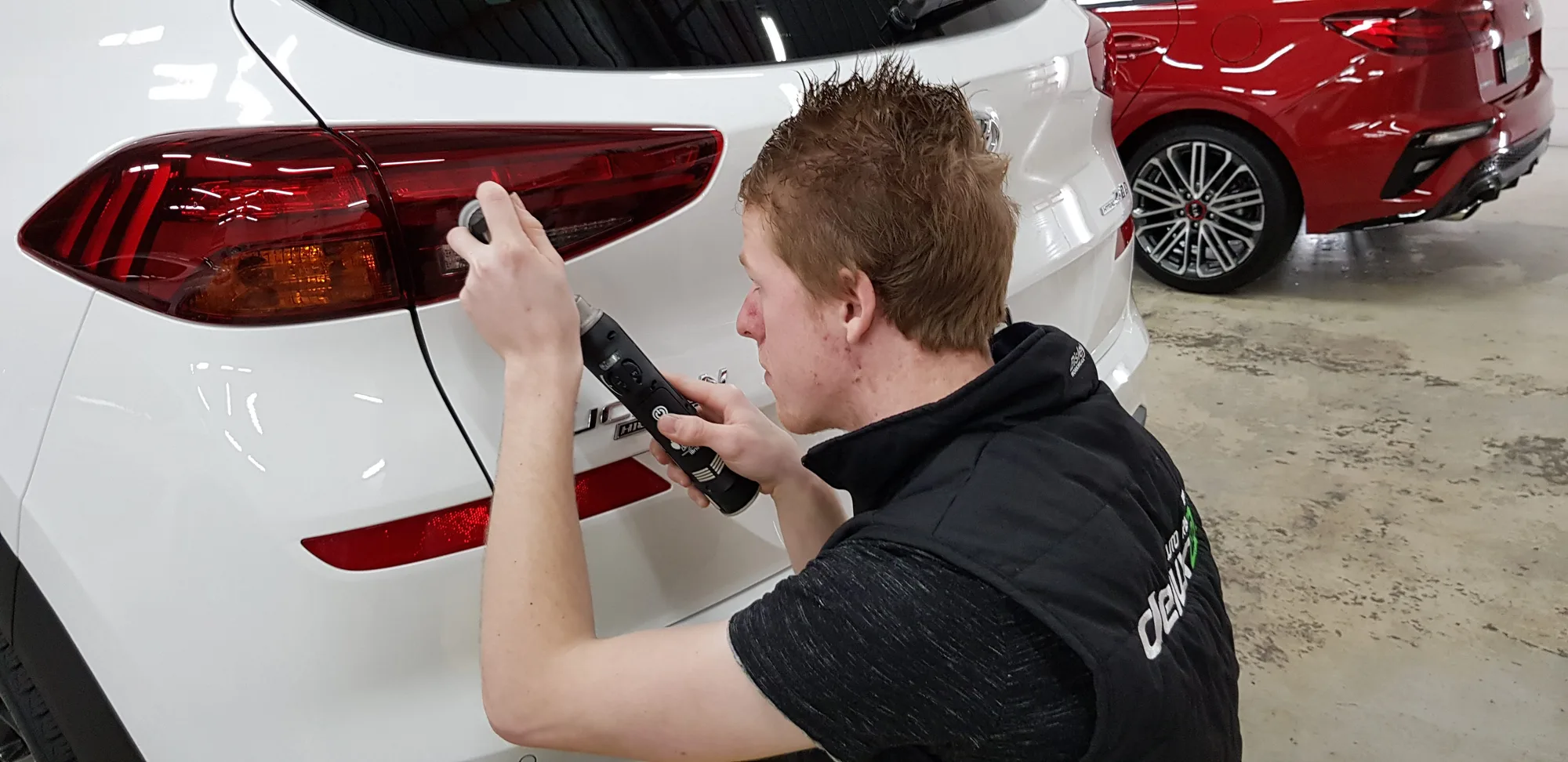 Ceramicar detailer applying ceramic coating around the taillight of a white Range Rover