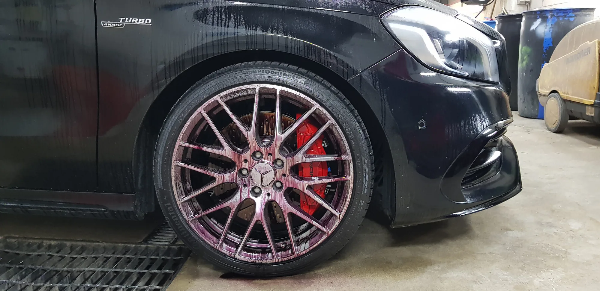 Red brake calipers and coated alloy wheel on a black Mercedes-AMG A45 at Ceramicar Adelaide