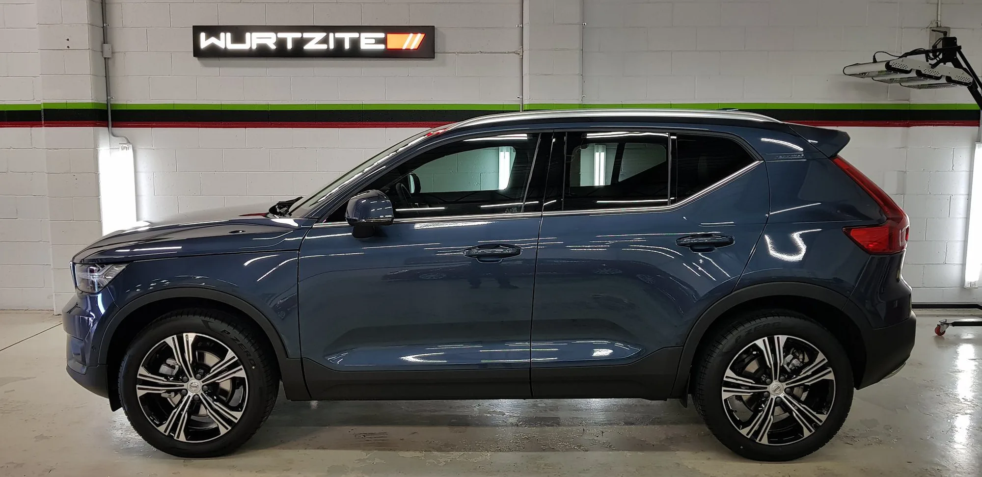 Blue Volvo XC40 with tinted windows parked under the Wurtzite sign at Ceramicar Adelaide